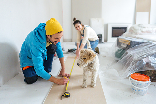 Haus Modernisieren Paar mit Hund misst Fläche ab